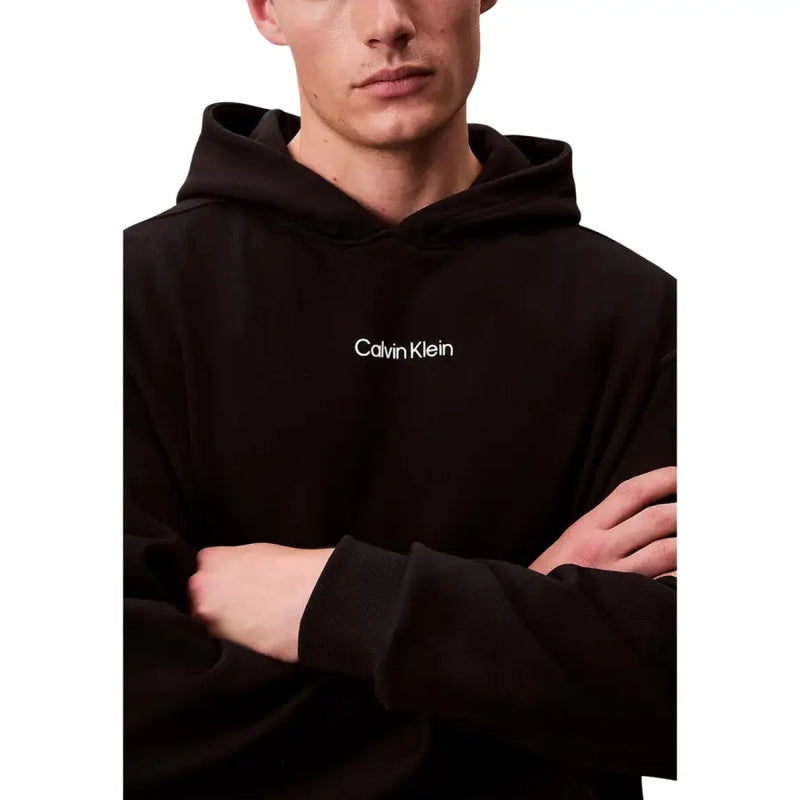 Calvin Klein Sweat à capuche noir en coton pour homme, avec logo brodé blanc sur la poitrine.