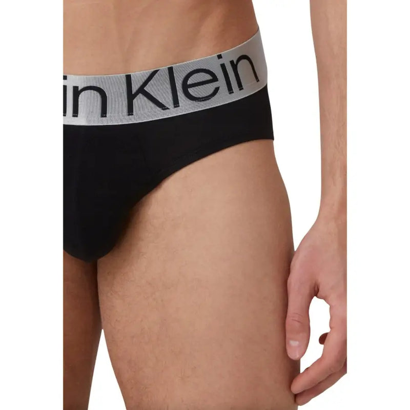Schwarz Calvin Klein Herrenslips mit grauem Bund und dem Aufdruck Calvin Klein Logo in schwarzer Schrift