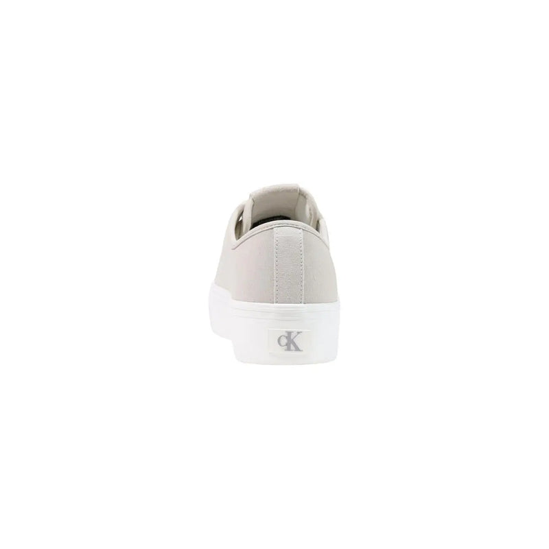 Light gray canvas slip-on sneaker with white rubber sole and Calvin Klein logo on the heel back side shown