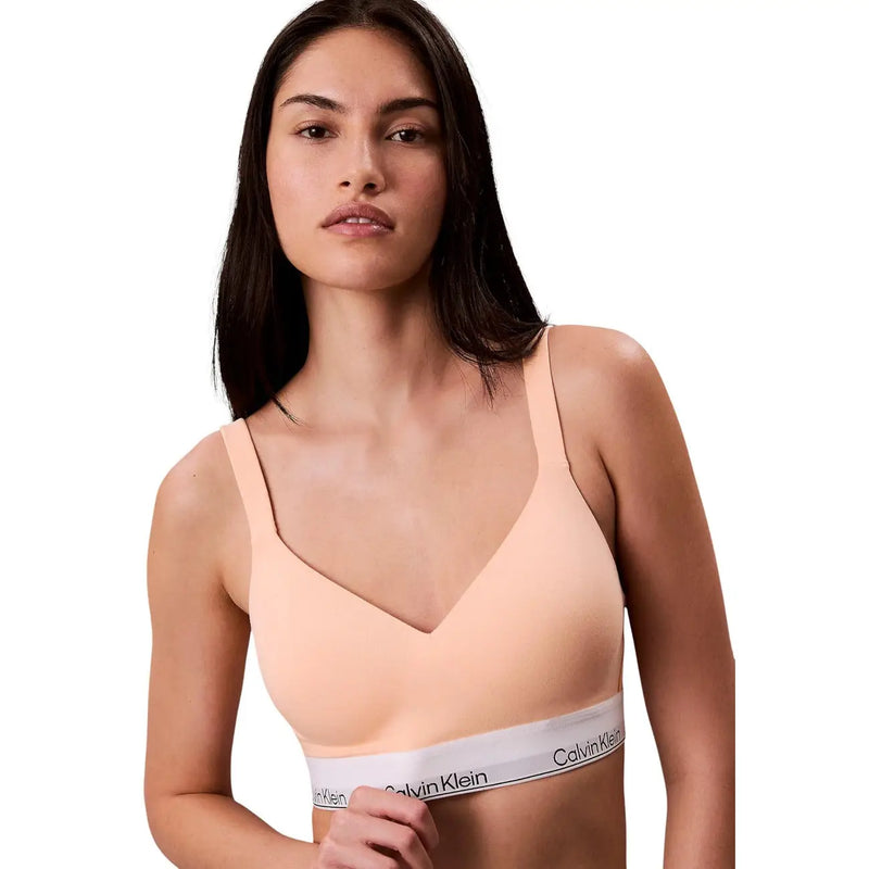 A soft peach calvin klein women lift bralette with thin straps and white cotton modal stretch elastic band