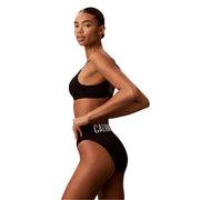 Black calvin klein bikini bottom with white logo band shown from the back made of polyester material