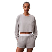 Gray cropped sweatshirt with small chest pocket featuring calvin klein logo paired with black jersey cotton shorts