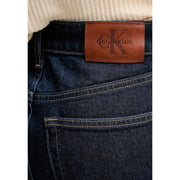 Dark blue cotton denim jeans for women with brown leather calvin klein patch on waistband fall winter style back view