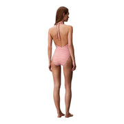A woman wears a Calvin Klein womens orange striped one-piece nylon swimsuit with red and white halter neck straps