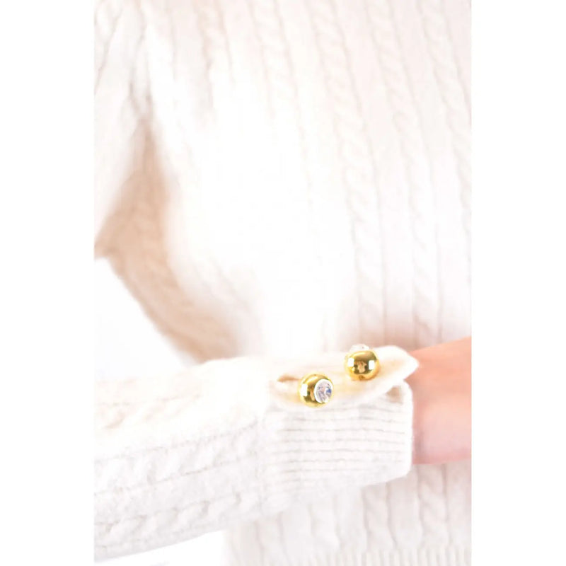 Gold-toned spherical cufflinks with crystal accent worn on sleeve of chiara ferragni women white wool knitwear round neck