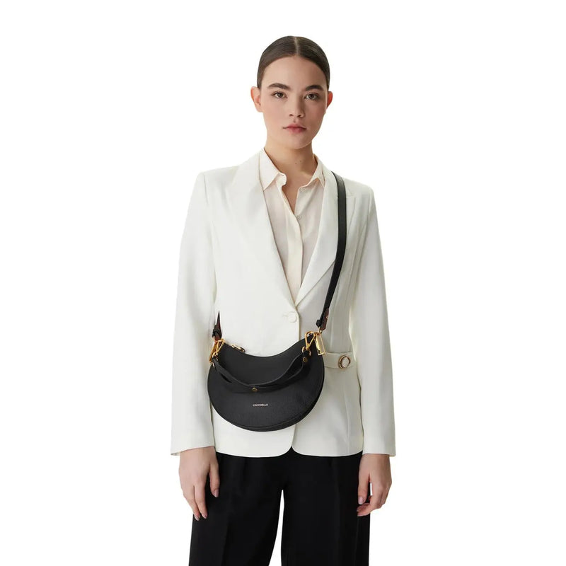 Black leather crescent-shaped crossbody bag by Coccinelle with gold-tone hardware and grey zip pockets 24x16x5cm