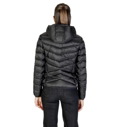 Woman wearing a black hooded puffer jacket and black pants from Colmar Originals