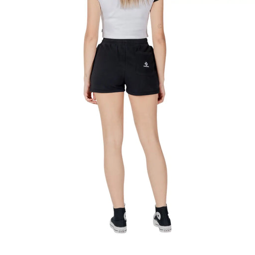 Back view of converse women black cotton fleece shorts featuring a small white star chevron logo on the pocket
