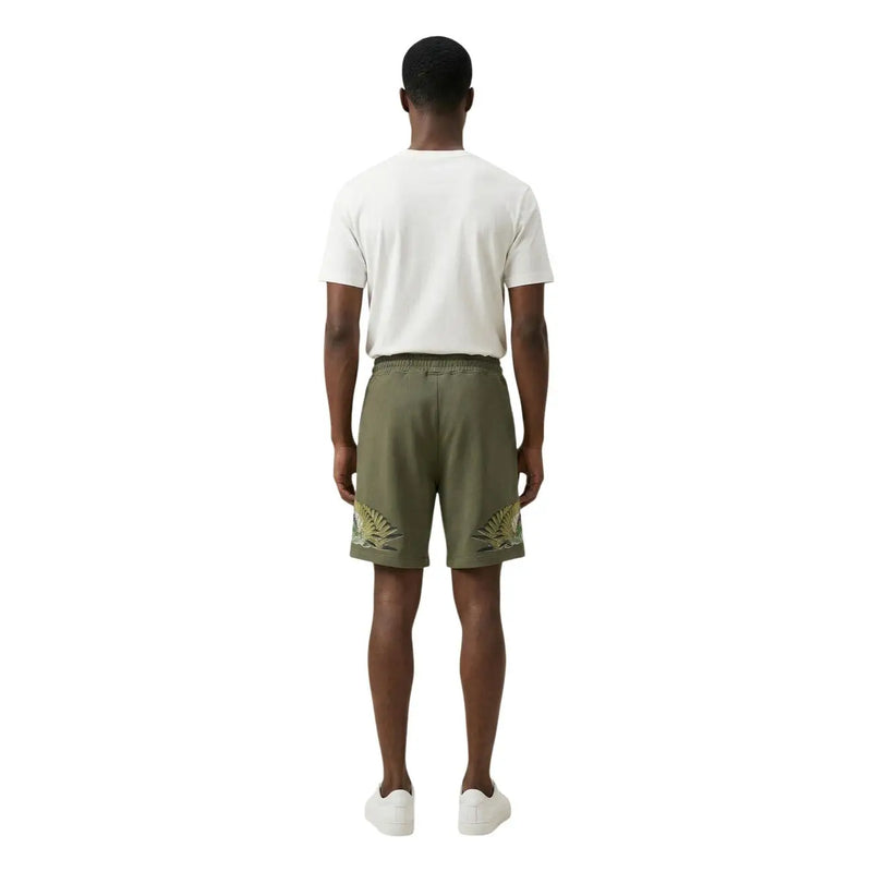 Short en coton pour homme County of Milan, vert olive, orné de broderies dorées en forme de feuilles de palmier (vue de profil).