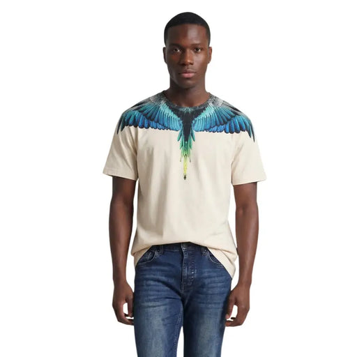 Beigefarbenes, kurzärmeliges Herren-T-Shirt aus Baumwolle von County of Milan mit leuchtend blau-grünem Flügelmotiv auf den Schultern