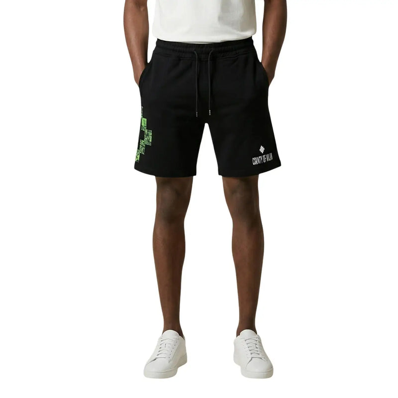 County of Milan shorts for men in black cotton with green pixelated cross and white branding, front view