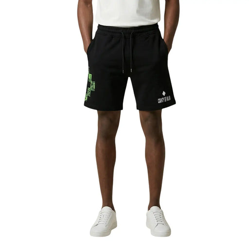 County of Milan shorts for men in black cotton with green pixelated cross and white branding, front view