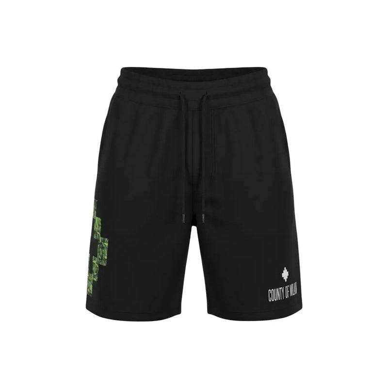 County Of Milan shorts for men in black with green pixelated cross and white logo, front view