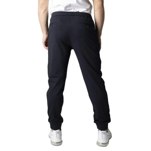 Dark blue men’s trousers displayed alongside black athletic sweatpants in a product image