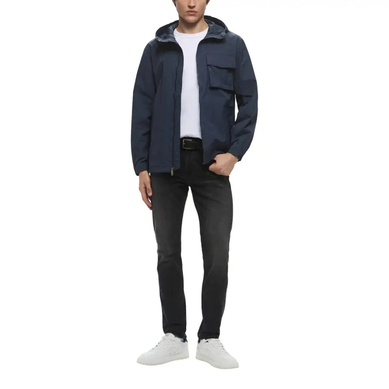 Dark navy hooded jacket with sleek modern design and two front pockets paired with dark wash jeans by calvin klein