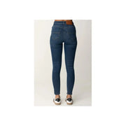 Dark wash blue denim high waisted skinny jeans displayed in a fashion product image