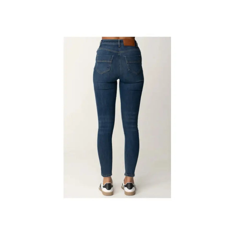 Dark wash blue denim high waisted skinny jeans displayed in a fashion product image