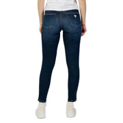 Dark wash skinny denim jeans in dark blue with a fitted cut and a small guess logo on the back pocket shown from the back