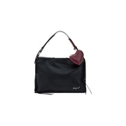 Desigual black handbag with braided shoulder strap and zip pockets featuring a burgundy heart-shaped charm