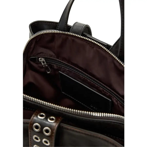 Black leather tote bag with silver zippers and studded strap details shown with desigual brown polyester rucksack with zip pockets