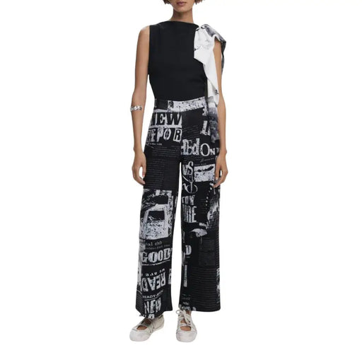 Black and white sleeveless jumpsuit with newsprint pattern and front zip detail