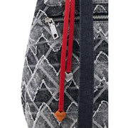 Red leather strap with heart-shaped charms attached to black and white geometric patterned Desigual grey cotton rucksack