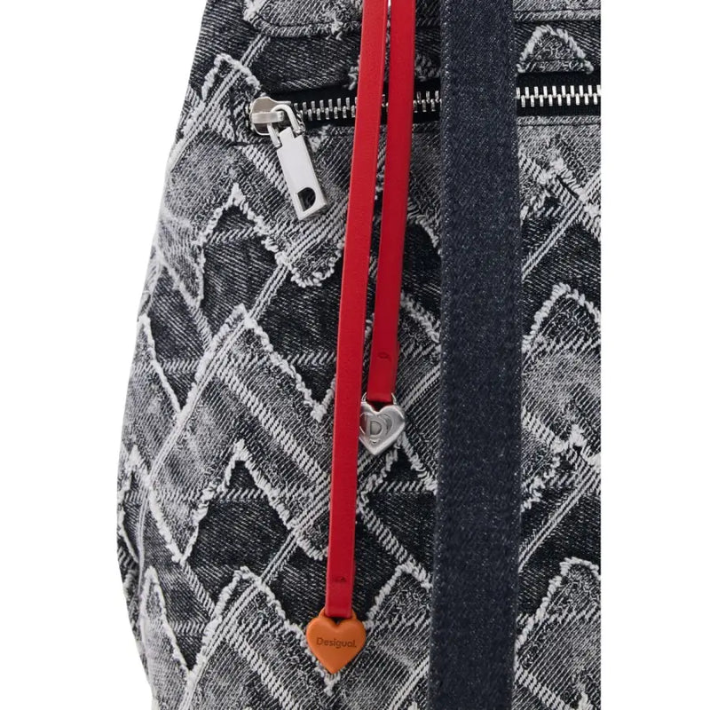 Red leather strap with heart-shaped charms attached to black and white geometric patterned Desigual grey cotton rucksack