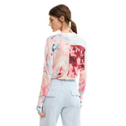 A woman wears desigual pink floral long sleeve round neck viscose knitwear with a soft flowing fabric