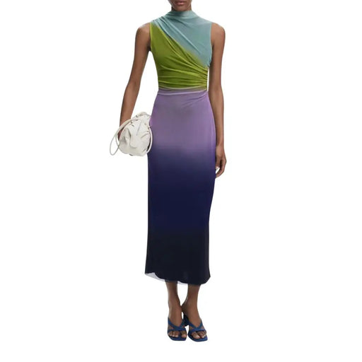 Green and blue sleeveless high-neck top with asymmetrical draped design paired with purple ombré maxi skirt and blue flip-flop heels with white ruched handbag