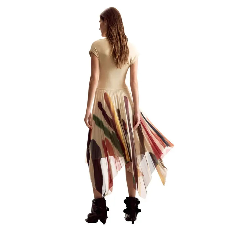 A woman wearing a desigual women beige printed short dress with asymmetrical translucent panels and abstract brushstroke patterns