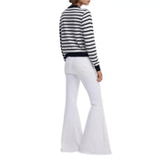 White flared denim jeans paired with Desigual women black striped round neck knit sweater front view