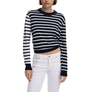 Woman wearing navy and white striped round neck knit sweater with white jeans