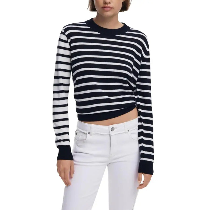Woman wearing navy and white striped round neck knit sweater with white jeans