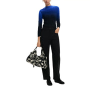 Desigual women black viscose trousers with pockets paired with a black and white patterned shoulder bag featuring overlapping belt buckles