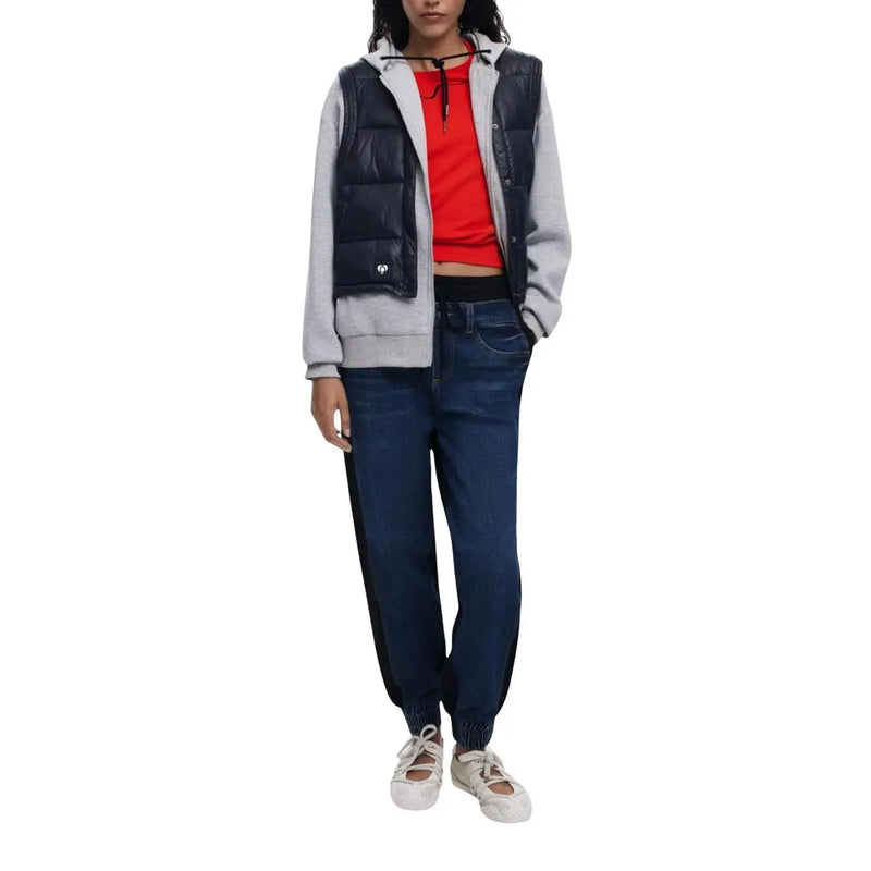 Marineblaue Steppweste mit grauen Ärmeln und Frontreißverschluss, kombiniert mit einer dehnbaren, blauen Baumwoll-Jeans von Desigual für Damen.