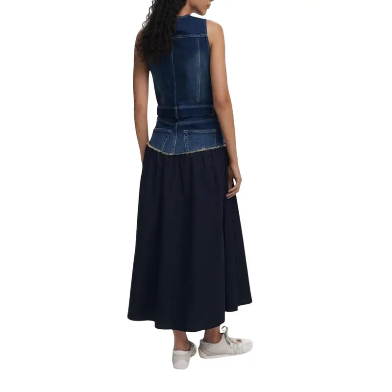 Woman wearing a dark denim sleeveless top and long navy skirt, showcasing Desigual dress