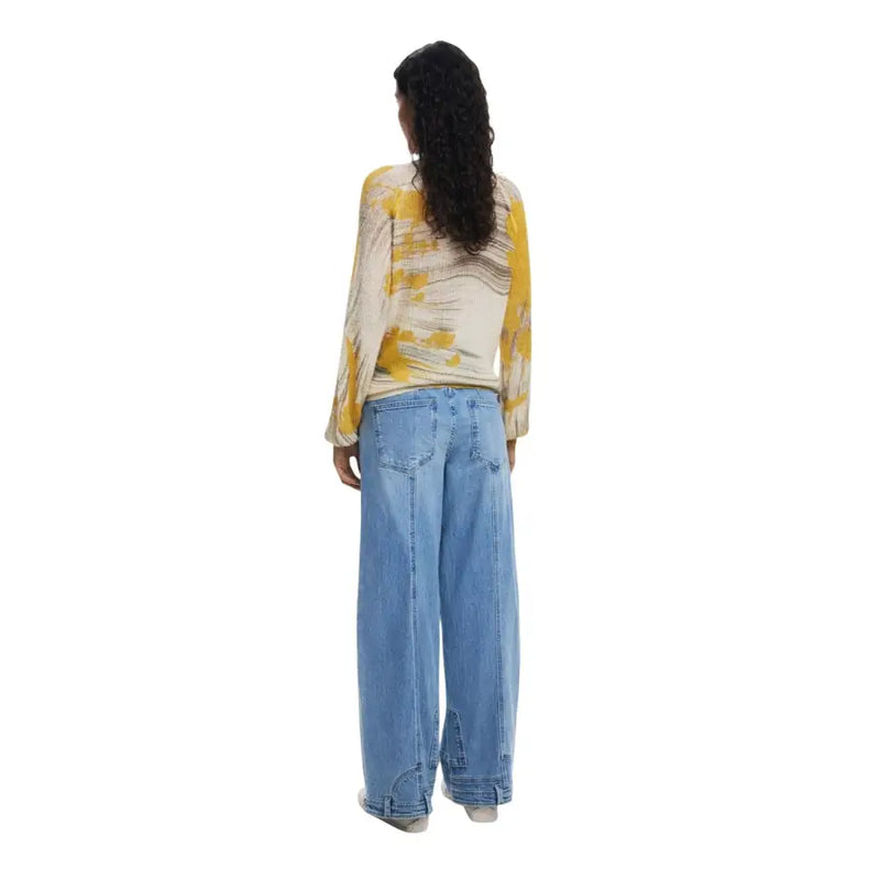 Woman wearing yellow and white long-sleeve top with wide-leg blue jeans from Desigual Fall Winter collection
