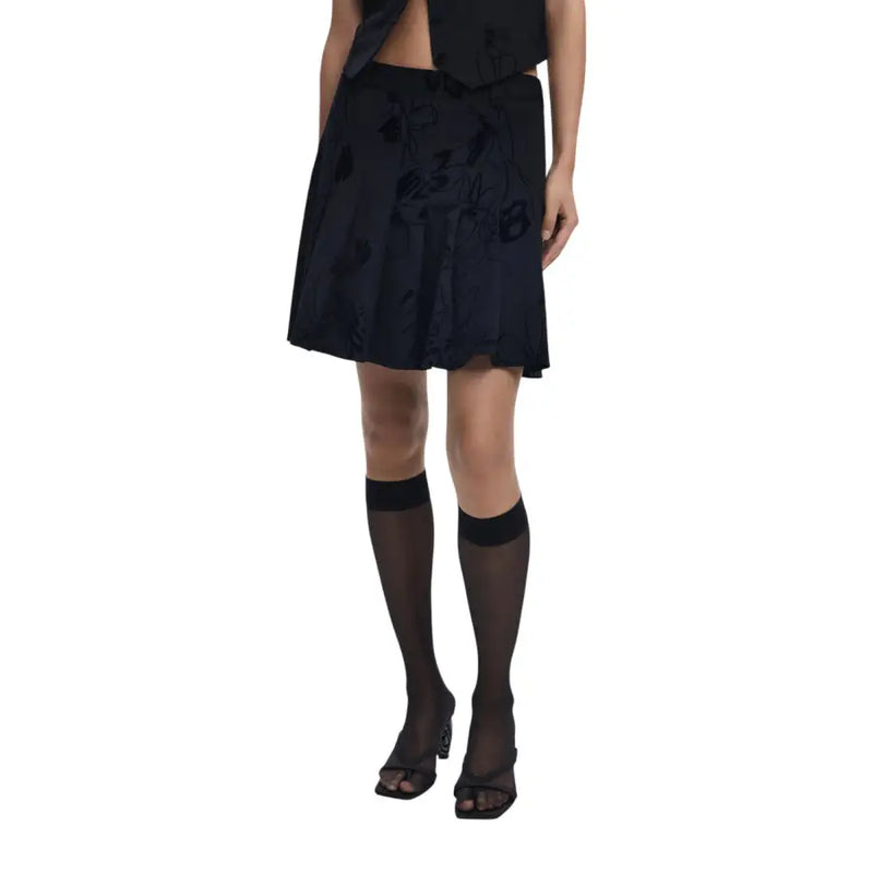 Black knee-length skirt with floral embroidery paired with sheer knee-high socks and open-toed heels