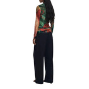 Woman wearing Desigual green viscose round neck long knitwear with floral pattern and black trousers