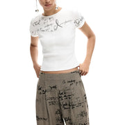 White short-sleeved top with black handwritten-style text paired with desigual women grey pattern zip viscose blend trousers