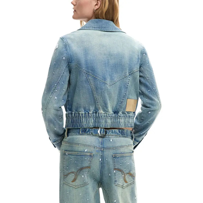 Back side of a desigual women light blue cropped denim jacket with distressed white paint splatter and brown stitching pockets