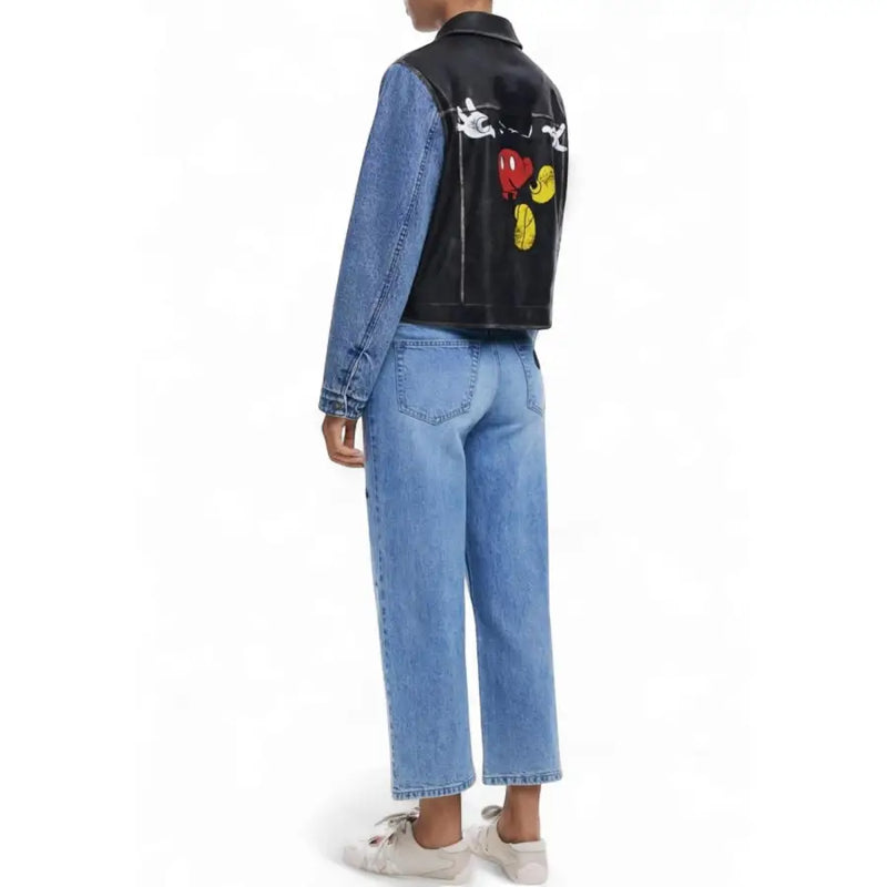 Women wearing black leather and denim jacket with Mickey Mouse graphics and light wash jeans
