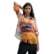 A flowing semi-sheer Desigual women orange polyester blouse with vibrant abstract print in shades of orange blue and yellow
