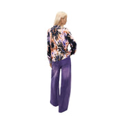 A woman wears a desigual women pink floral cotton knit sweater with a vibrant purple black and peach tie-dye blouse