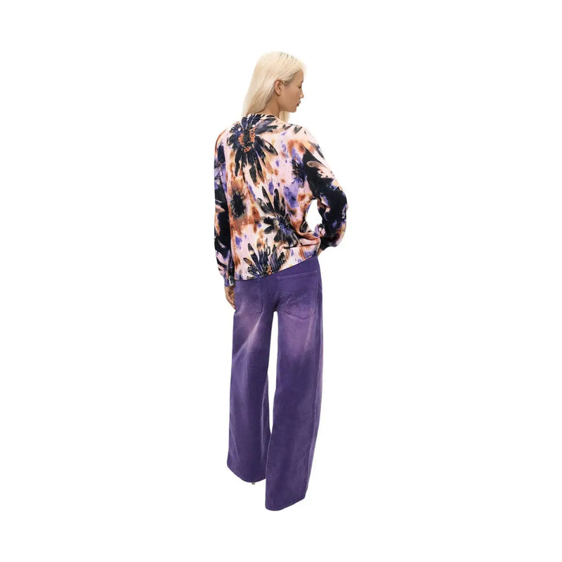 A woman wears a desigual women pink floral cotton knit sweater with a vibrant purple black and peach tie-dye blouse