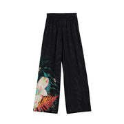 Black wide-leg viscose trousers by desigual featuring vibrant tropical floral print with pink blossoms and orange leaves