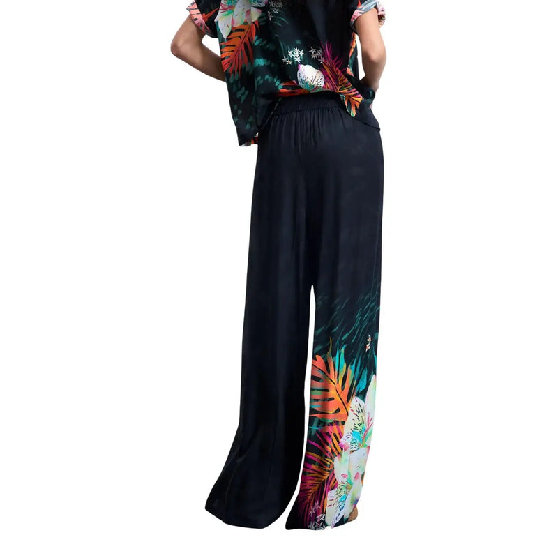 Desigual women black wide-leg viscose trousers with vibrant orange green and pink tropical leaf print on lower legs
