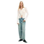 A woman wears a desigual white viscose long-sleeved lace button-up shirt with light-wash floral embroidered jeans