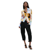 A woman wears a desigual women yellow floral viscose long shirt with abstract dog pattern and black cargo pants