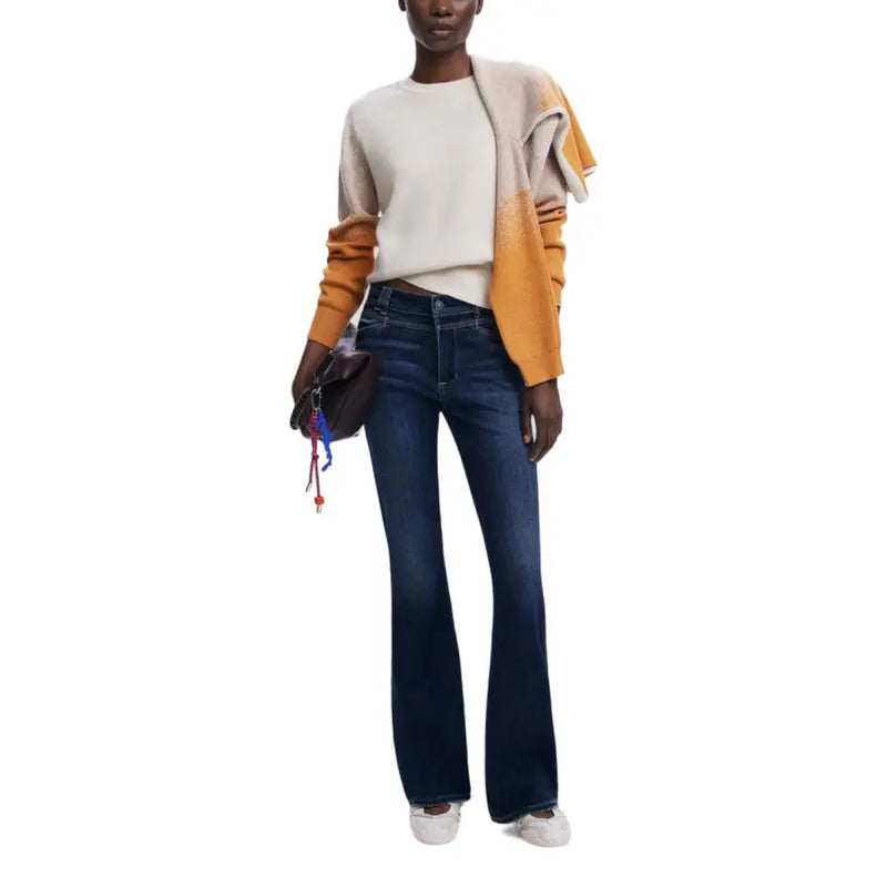 Dunkelblaue Schlagjeans aus Denim an einem beigefarbenen Strickpullover von Desigual.